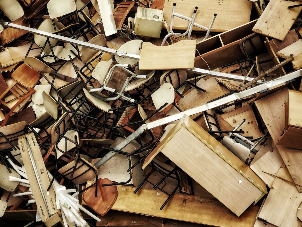 Entrümpelung entsorgen – Haufen ausrangierter Holzmöbel und Stühle