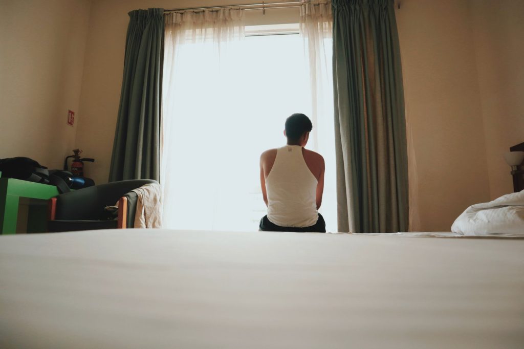 Bipolarität und Beruf – Person sitzt nachdenklich vor einem hellen Fenster