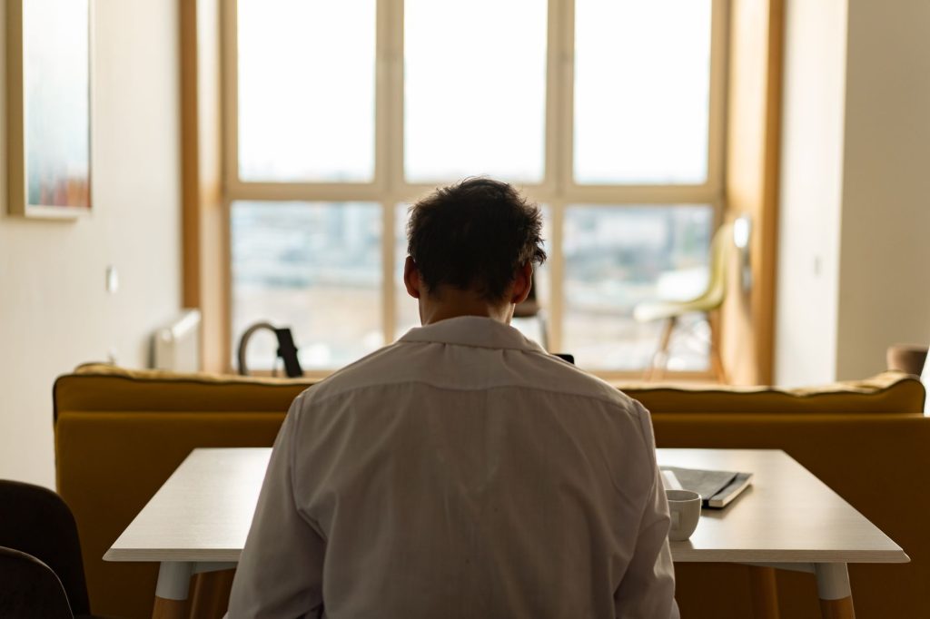 Berufe bei Bipolarität – Mann arbeitet in Ruhe an einem hellen Arbeitsplatz