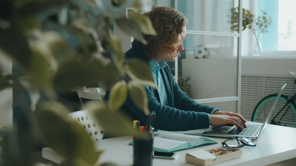 Copywriter am Computer – Texter arbeitet am Laptop im hellen Büro