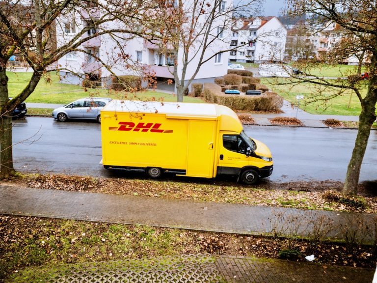 yellow and white box truck parked on sidewalk during daytime