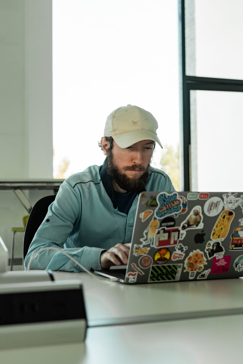 a man sitting at a desk working on a laptop
