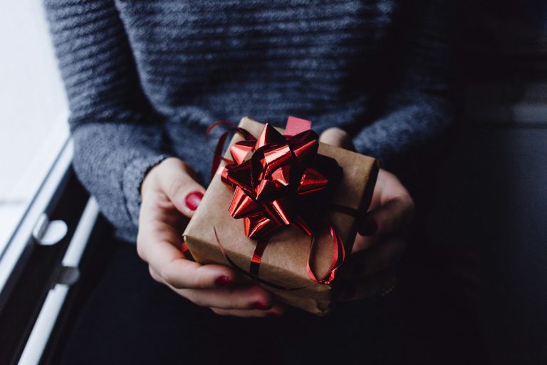 Mit diesen Tricks und Tipps die Werbeartikel noch effektiver einsetzen person holding present box