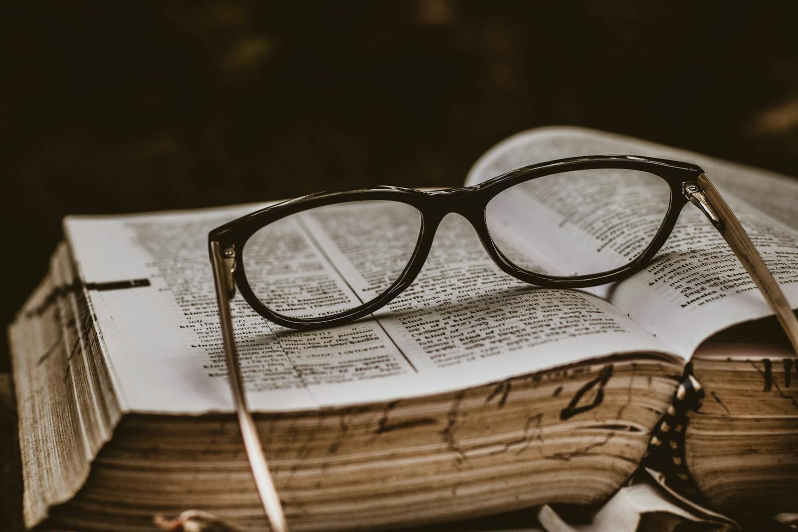 Close-up of eyeglasses on an open book, symbolizing study and knowledge.