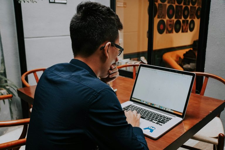Sichere Skalierung: Warum junge Wachstumsunternehmen früh eine professionelle Passwortstrategie brauchen a man sitting at a table using a laptop computer