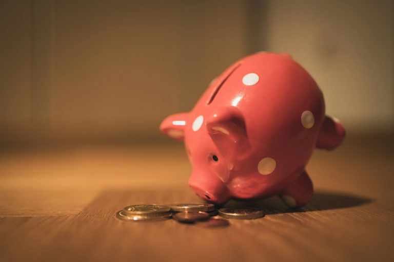 Nebenbeschäftigung, Sparen und Liquidität: Eine Finanzstrategie für Start-up-Mitarbeiter pink pig coin bank on brown wooden table