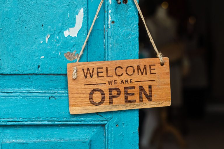 Bezahlbares Branding mit Schildern – Holzschild Welcome we are open an blauer Tür