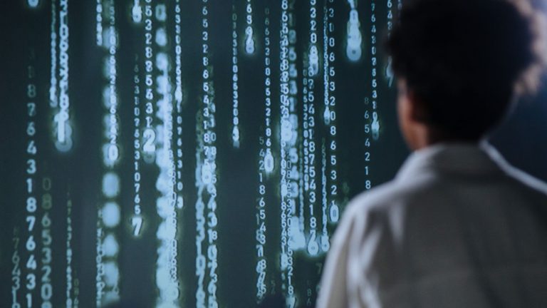 Wie revolutionieren Cloud-KI-Modelle die Startup-Welt? Cloud-KI-Modelle für Startups – Person vor leuchtenden Datenreihen