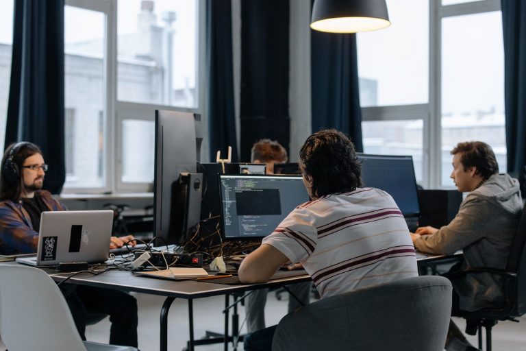 IT-Fachkräfte für Startups: Eigenrecruiting oder Personalvermittler im Vergleich IT-Fachkräfte für Startups: Entwicklerteam bei der Arbeit im Büro