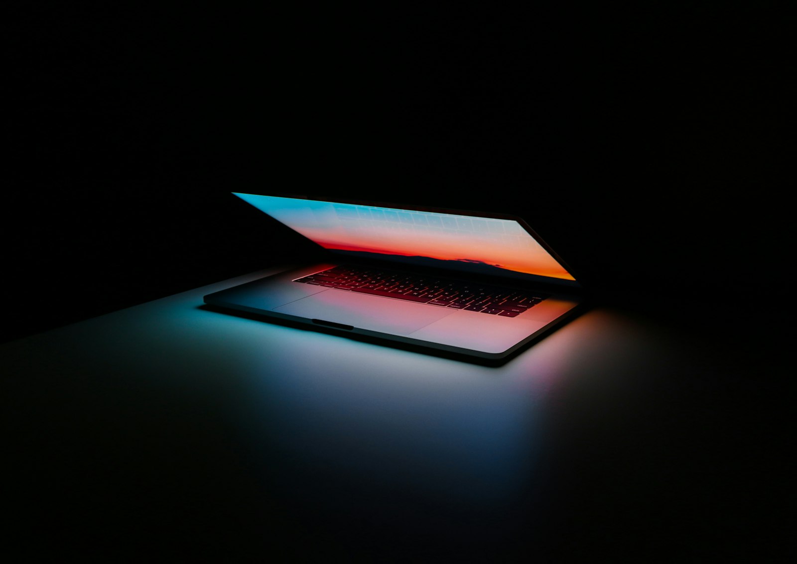 Digitale Grundausstattung für Startups – halb geöffneter Laptop im Dunkeln